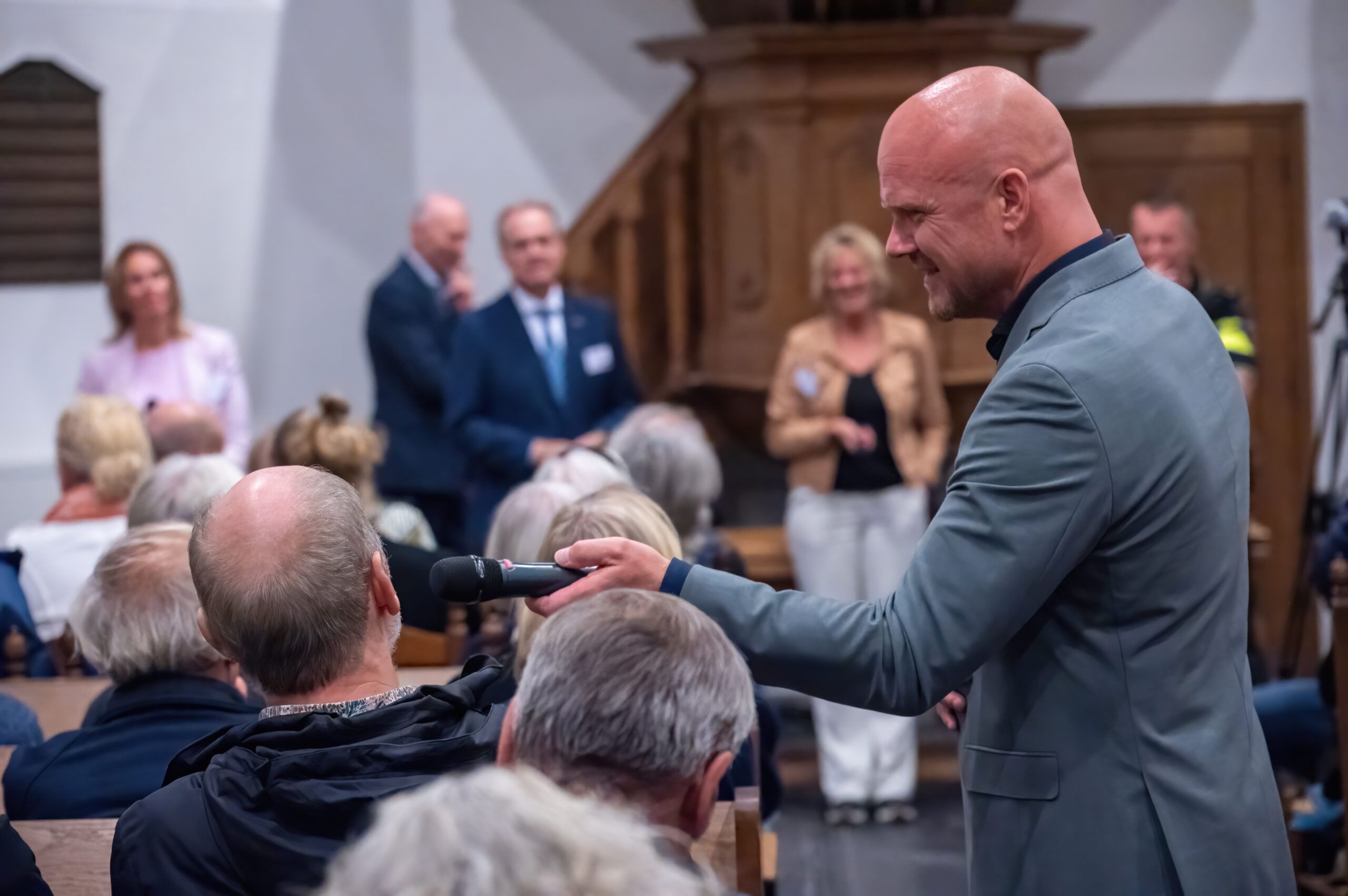 Johan Simon interviewt een bezoeker van de infoavond over opvang AMV in Schoorl